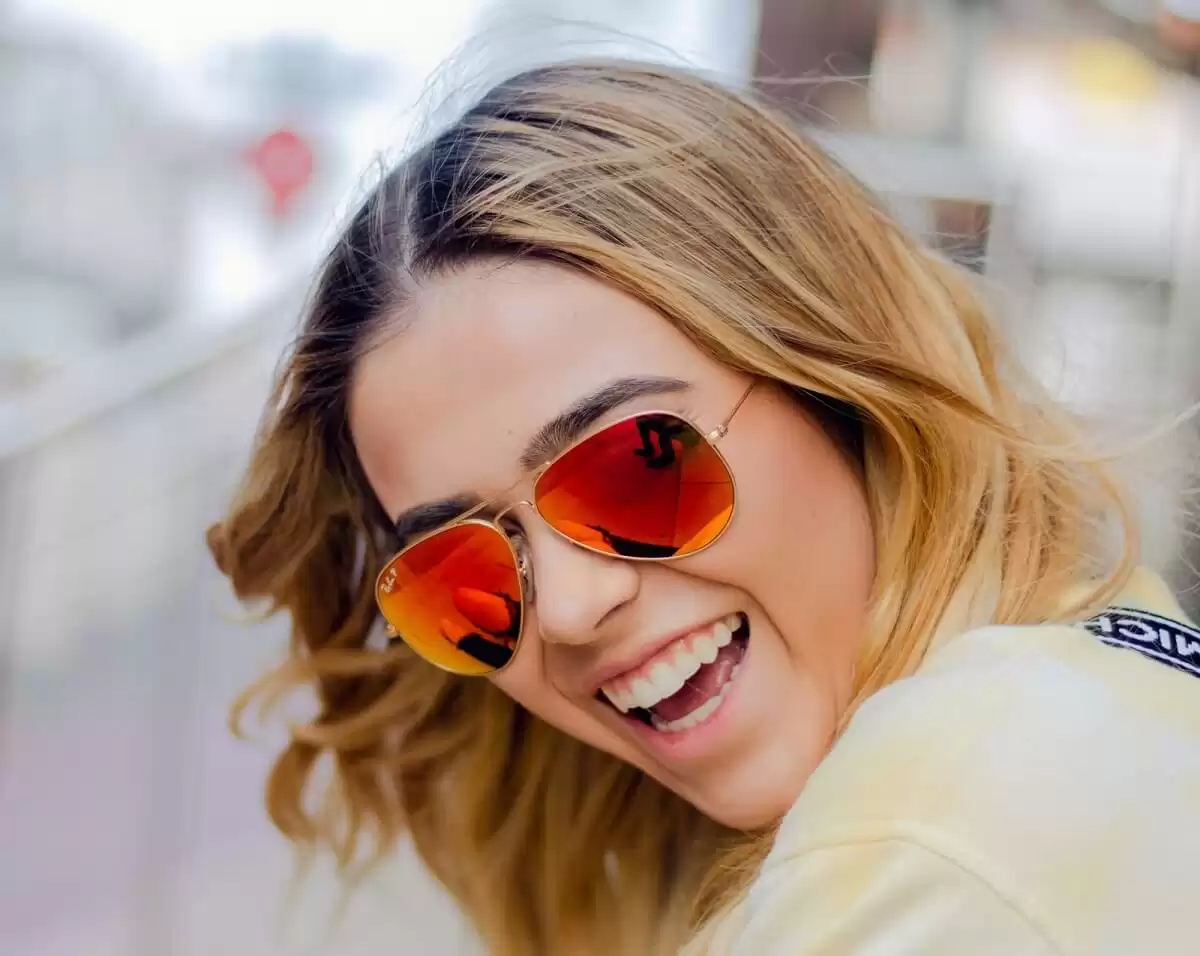 Woman wearing orange hue aviator sunglasses Woman wearing orange hue aviator sunglasses