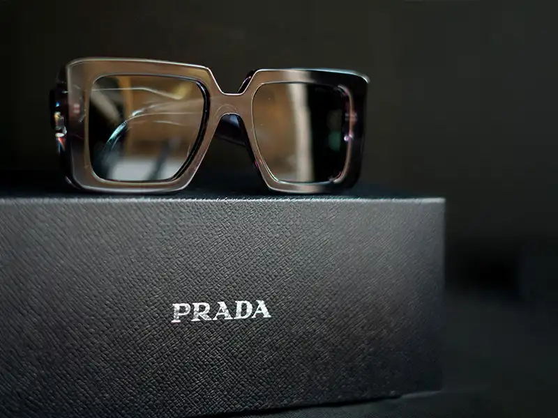 Authentic Prada sunglasses displayed on a textured black Prada case, showcasing premium packaging as an authenticity clue