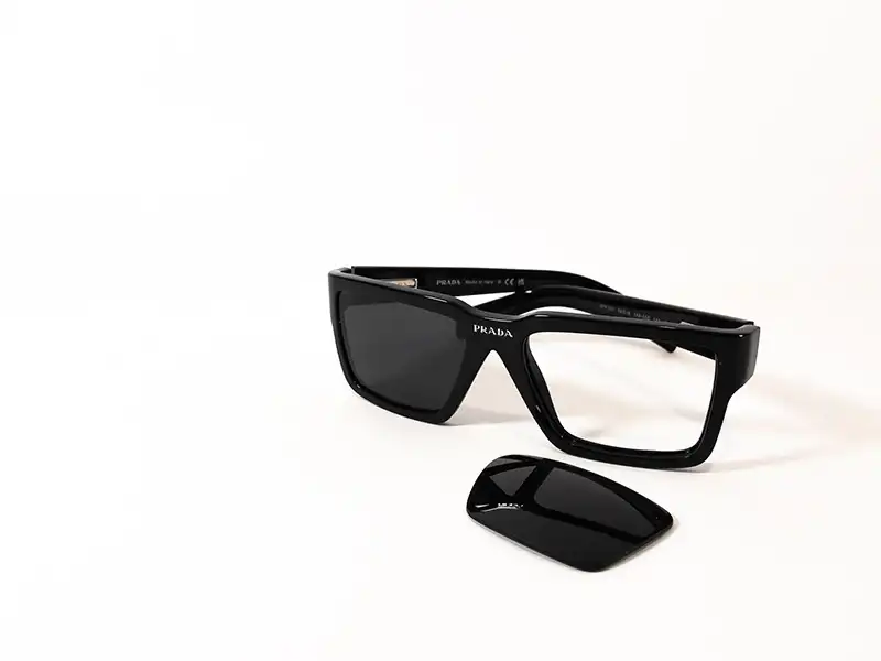 Black Prada sunglasses with one lens removed, demonstrating how to install a Prada replacement lens to restore authentic frames