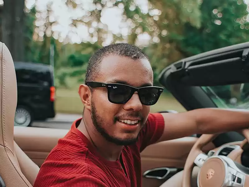 Mann beim Fahren und Tragen einer schwarzen Sonnenbrille