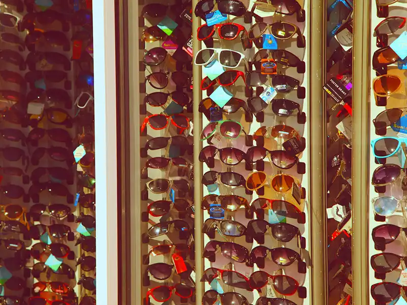 Massenproduzierte Sonnenbrillen auf einem Verkaufsständer, stellvertretend für Fast-Fashion-Brillen