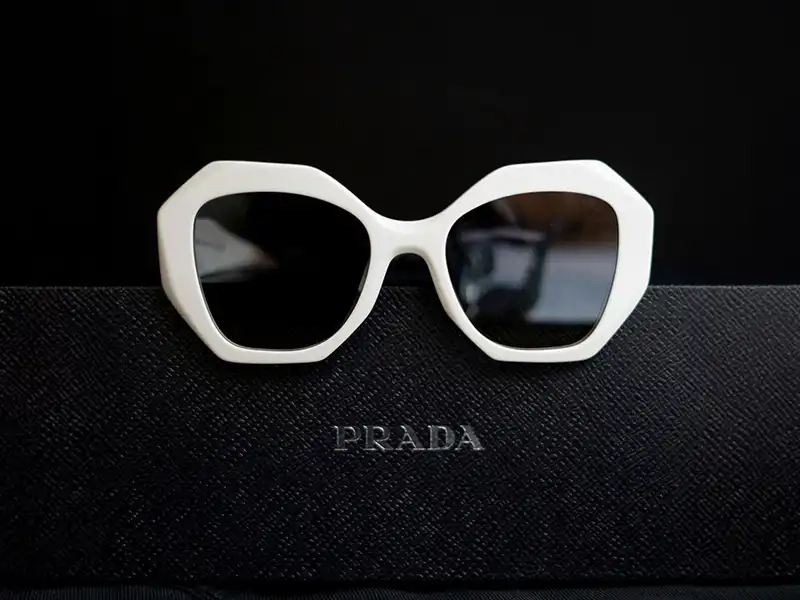 Weiße geometrische Sonnenbrille von Prada, die den kühnen und futuristischen Schildtrend für 2025 repräsentiert.