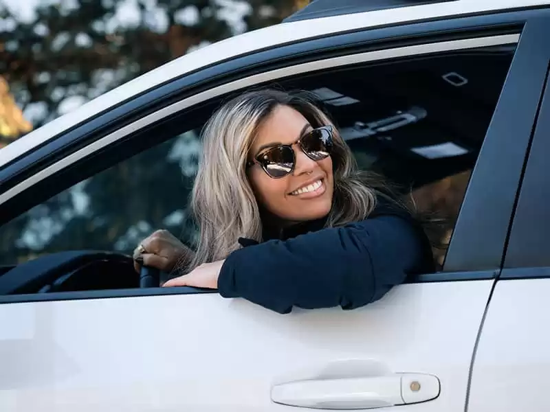 mujer conduciendo y usando gafas de sol polarizadas