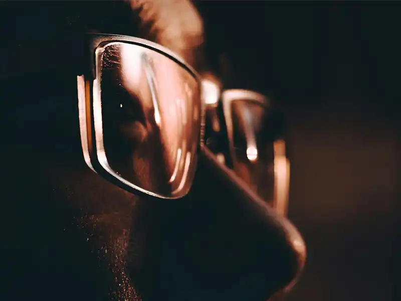 Primer plano de unas gafas de sol mostrando cómo los lentes protegen los ojos, con reflejos visibles.