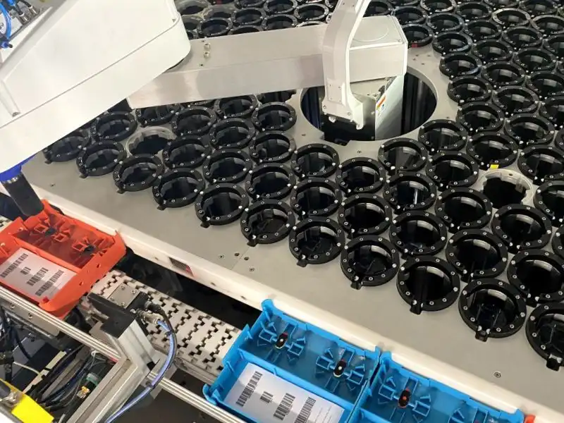La máquina de selección elige las lentes correctas para cada pedido durante el proceso de producción de lentes para gafas de sol