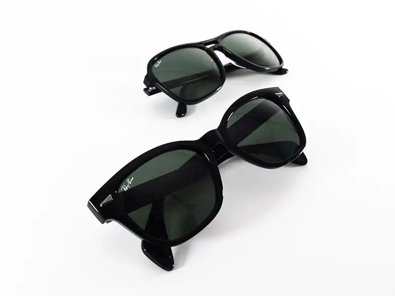 Dos pares de gafas de sol mostrados para comparar el acabado de las lentes y el estilo de la montura