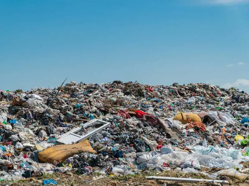 Vaste décharge remplie de déchets plastiques, illustrant l'impact environnemental des matériaux mis au rebut.