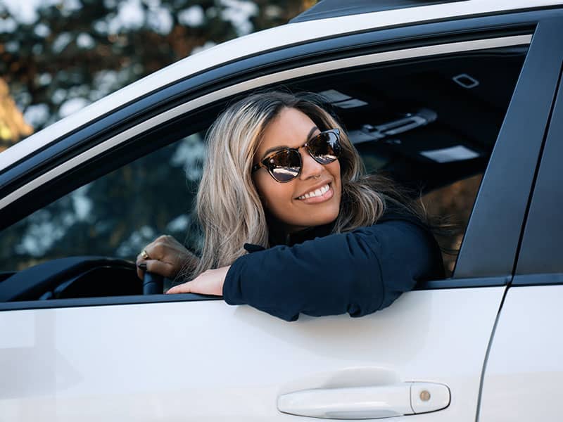 Frau fährt Auto und trägt polarisierte Sonnenbrille