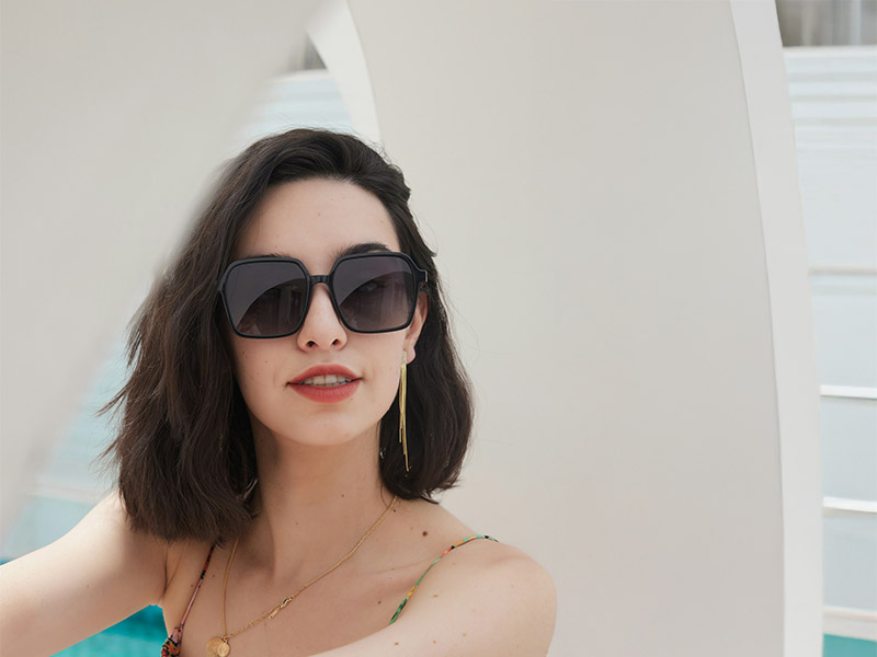 Woman wearing oversized square-frame sunglasses, reflecting the bold glamour trend for 2025 fashion eyewear.