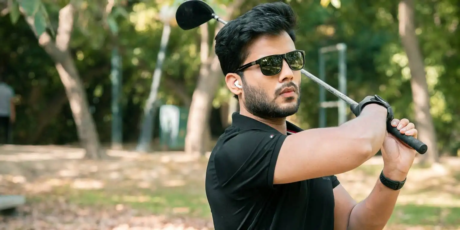 Man in black shirt wearing black Ray-Ban sunglasses