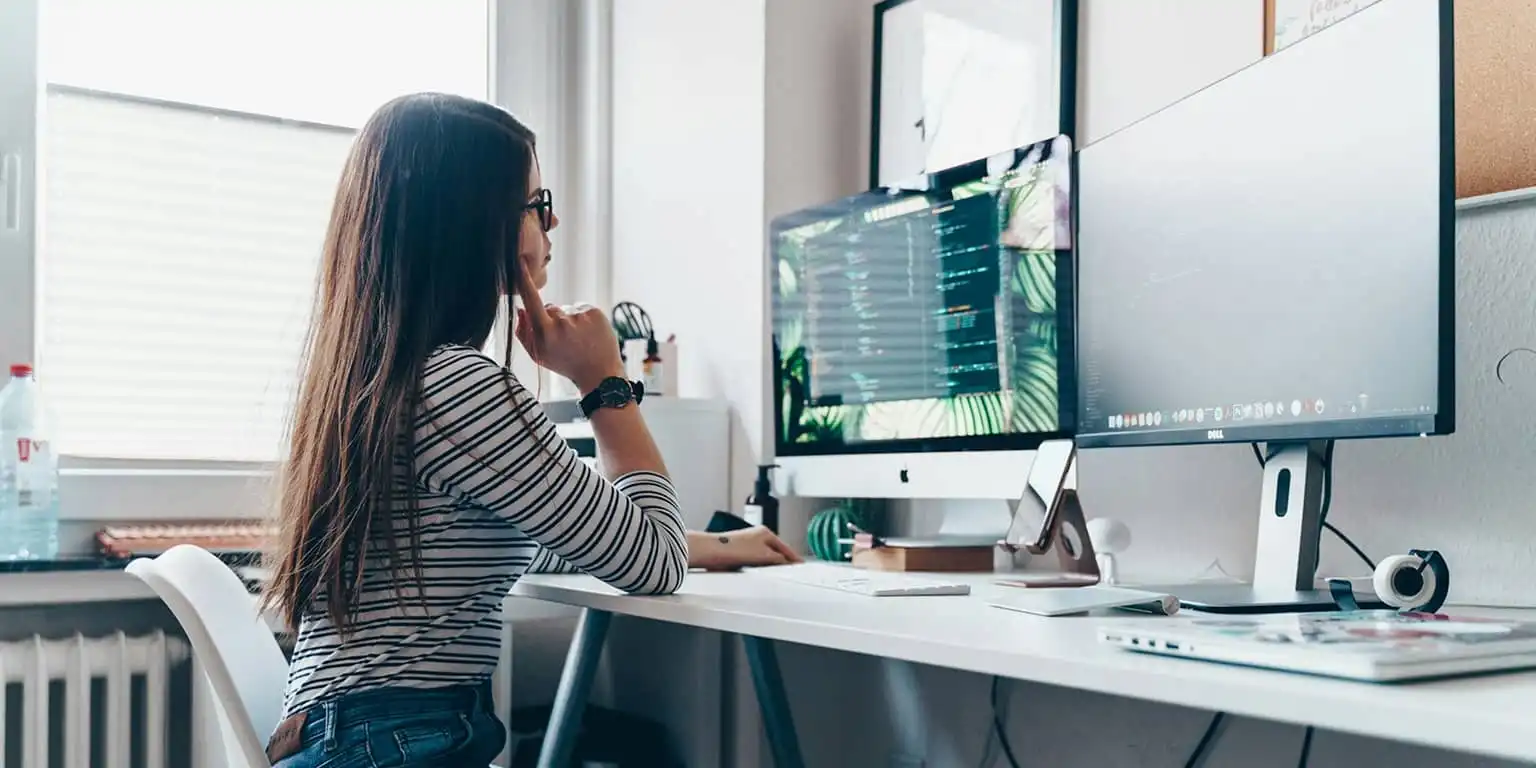 A Woman in an office infront of a computer wearing clean blue light blocking glasses