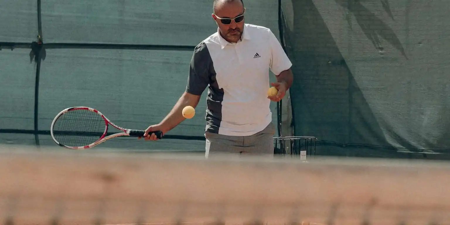 Man playing tennis wearing silver framed sunglasses with black lenses