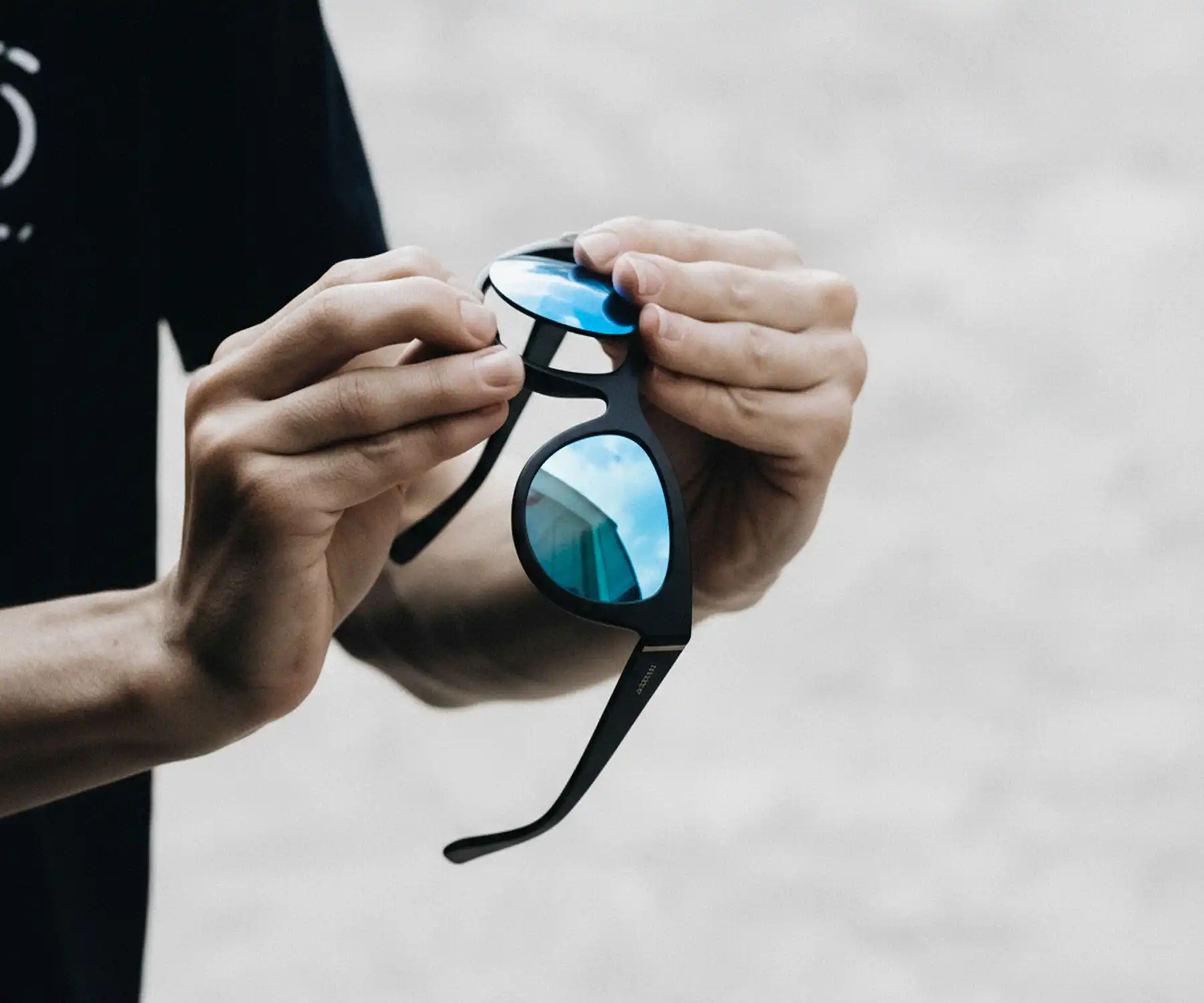 Sunglass fix employee installing blue mirrored lenses into a pair of black sunglasses